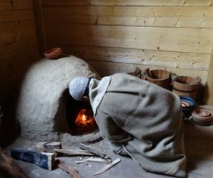 Człowiek rozpala ogień w piecu z gliny