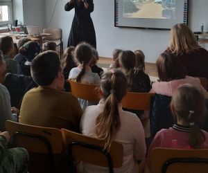 Misjonarz przedstawia dzieciom prezentację o warunkach życia ludzi w Afryce