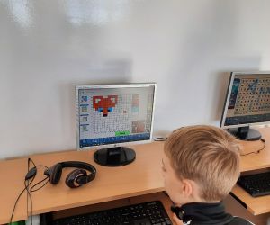 Uczeń rozwiązuje zadanie z kodowania na komputerze