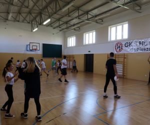 Dzieci biegają po hali sportowej