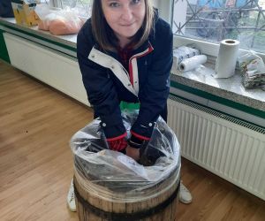 Nauczycielka ugniata kapustę w beczce