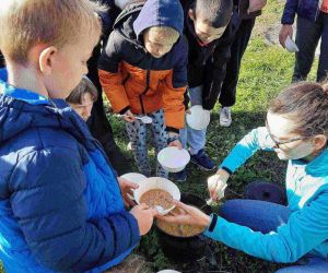 Uczniowie w kolejce po danie z kociołka