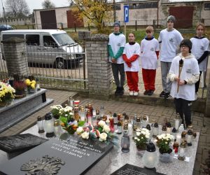 Grupa uczniów przy grobie żołnierzy
