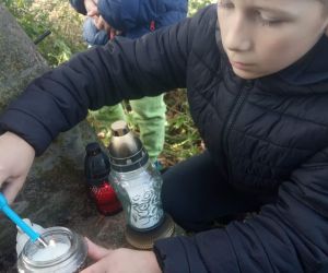 Uczeń zapala znicz