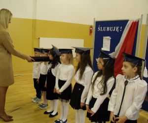 Pani dyrektor pasuje dziewczynkę z klasy pierwszej na uczennicę