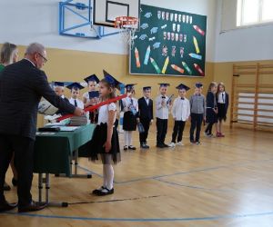 Dyrektor szkoły dokonuje symbolicznego pasowania na ucznia