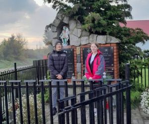 Zdjęcie przedstawia dwoje uczniów podczas zapalania zniczy przy tablicy upamiętniającej 15 Pułk Piechoty ”Wilków” w Stefankowicach