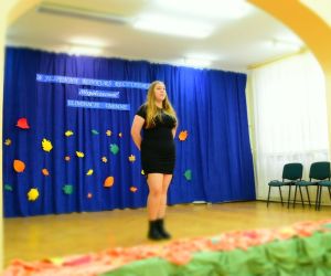 Zdjęcie przedstawia stojącą na scenie dziewczynkę.