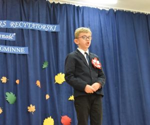 Zdjęcie przedstawia recytującego wiersz chłopca.