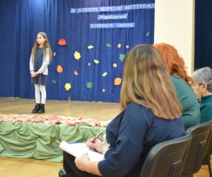 Zdjęcie przedstawia recytującą dziewczynkę.