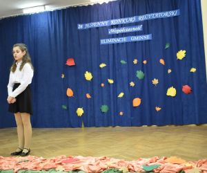 Zdjęcie przedstawia dziewczynkę występująca na scenie.