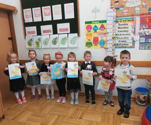 Młodsze przedszkolaki prezentują swoje prace plastyczne.