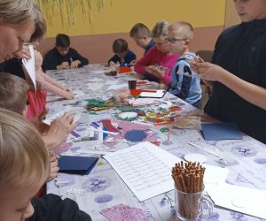 Na zdjęciu widoczne są dzieci wykonujące prace plastyczną.