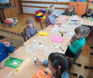 Młodsze przedszkolaki wykonują kartkę świąteczną