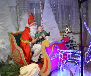 Mikołaj i dziecko siedzą w saniach