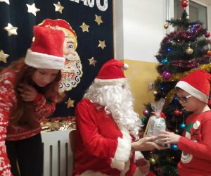 Chłopiec otrzymuje paczkę od Mikołaja