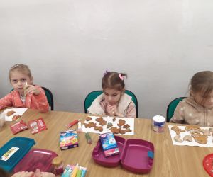 Dziewczynki dekorują pisakami pierniki