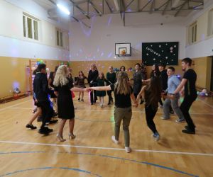 Nauczyciele tańczą z uczniami w kółeczku