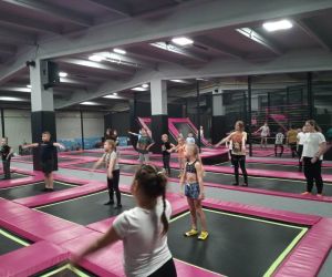 Zdjęcie przedstawia dzieci w trakcie zabawy w parku trampolin.