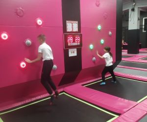 Zdjęcie przedstawia dzieci w trakcie zabawy w parku trampolin.