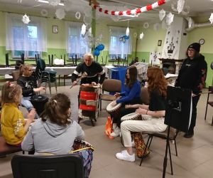 Zdjęcie przedstawia grupę osób w trakcie nauki gry na bębnach.