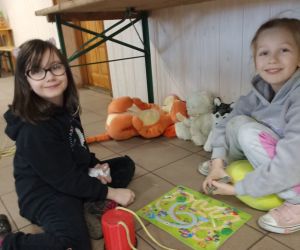 Zdjęcie przedstawia dwie dziewczynki grające w grę planszową.