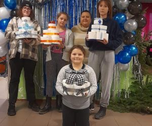 Zdjęcie przedstawia dzieci pozujące do zdjęcia wraz z papierowymi tortami.