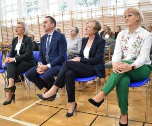 Osoby siedzą na sali