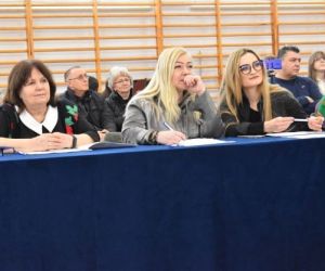 Osoby siedzą na sali