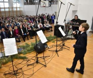 Osoba śpiewa na scenie przed publicznością