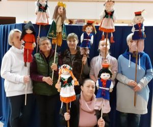 Na zdjęciu znajduje się sześć osób, które w rękach trzymają kukiełki użyte podczas przedstawienia pt. „O Krakowiaku i Krakowiance”. Kukiełki przedstawiają: trzy Krakowianki , trzech Krakowiaków, Król oraz Kat. Za  plecami tej grupy znajduje się parawan. 