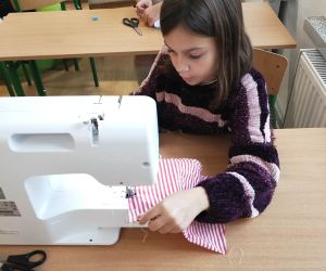 Dziewczynka szyje na maszynie 