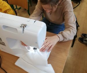 Dziewczynka szyje podczas zajęć kółka krawieckiego