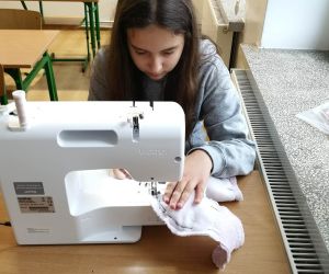 Dziewczynka szyje na maszynie