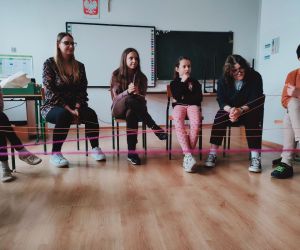 Grupa osób w klasie szkolnej podczas zabawy 