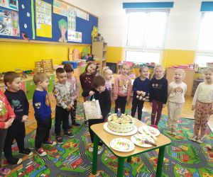 Marcel częstuje dzieci cukierkami.