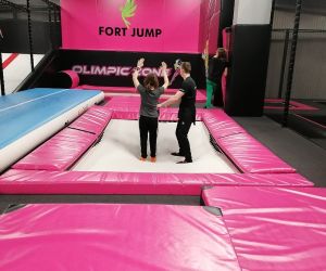 Instruktor tłumaczy uczennicy jak wykonać salto