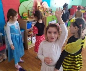 Grupa dziewczynek przebranych za postacie z bajek, bawi się i tańczy.