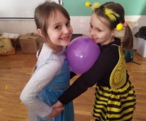 dwie dziewczynki tańczą z balonem