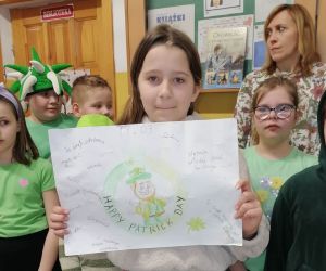 Uczennica trzyma plakat przygotowany z okazji Dnia św. Patryka