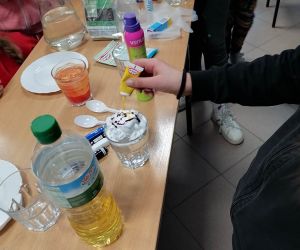 Uczennica przeprowadza doświadczenie- kolorowy deszcz