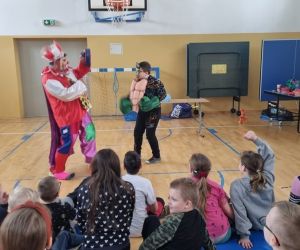 Klaun pokazuje chłopcu rękawice –bohatera z bajki Hulka