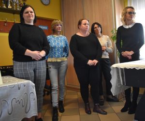 Zdjęcie przedstawia pięcioro dorosłych stojących wewnątrz budynku.