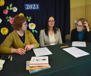 Zdjęcie przedstawia trzy kobiety siedzące przy stole.