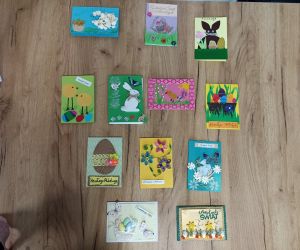 zdjęcie przedstawia rozłożone na stole kartki wielkanocne.