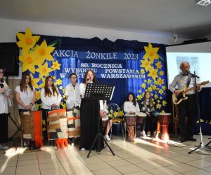 Zespół śpiewa i gra na scenie.