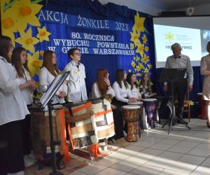 Zespół śpiewa i gra na scenie.