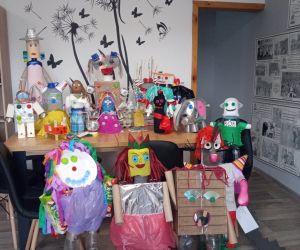 Roboty z recyklingu, ustawione na stole i połodze