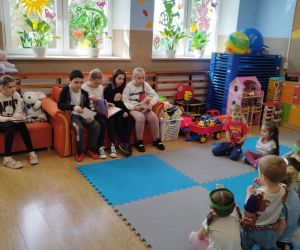Przedszkolaki słuchają bajek czytanych przez starszych kolegów w ramach projektu „Starsi czytają młodszym”