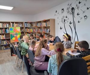 Zdjęcie przedstawia grupę osób siedzących przy stole.